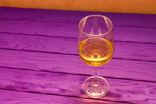 Białe wino w lampka na fioletowym tle drewna — Zdjęcie stockowe