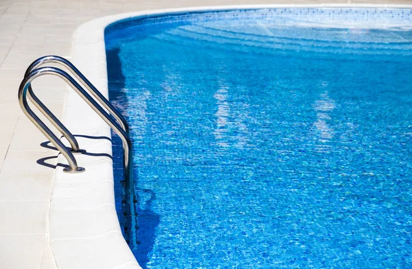 Σκάλα για την όμορφη πισίνα του ξενοδοχείου με μπλε νερό — Φωτογραφία Αρχείου