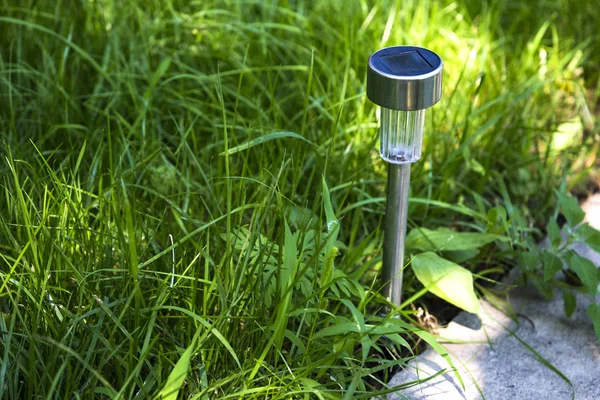 Hidden in grass lantern on solar battery — Stock Photo, Image