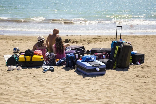 Сім'ї на пляжі які подорожують з великою кількістю валізи (b — стокове фото