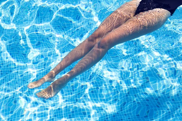 Schöne Beine eines Mädchens, das sich im Schwimmbad ausruht — Stockfoto