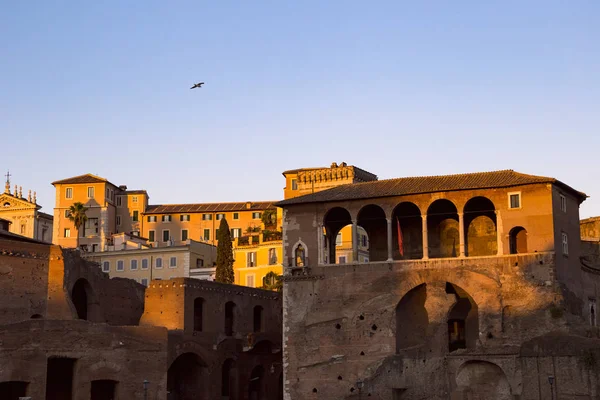 広場近くの日没の太陽に照らされたローマの古代建築物 — ストック写真