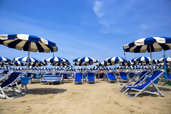 Блакитні пляжні парасольки і пляжні стільці — стокове фото