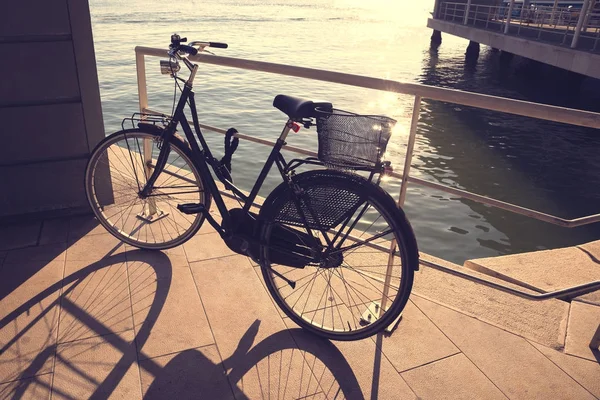 Bicicleta con cesta en la costa al atardecer — Foto de Stock