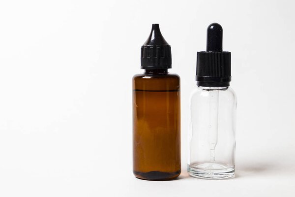 e- liquid, e-juice in the bottles isolated on the white background with copyspace