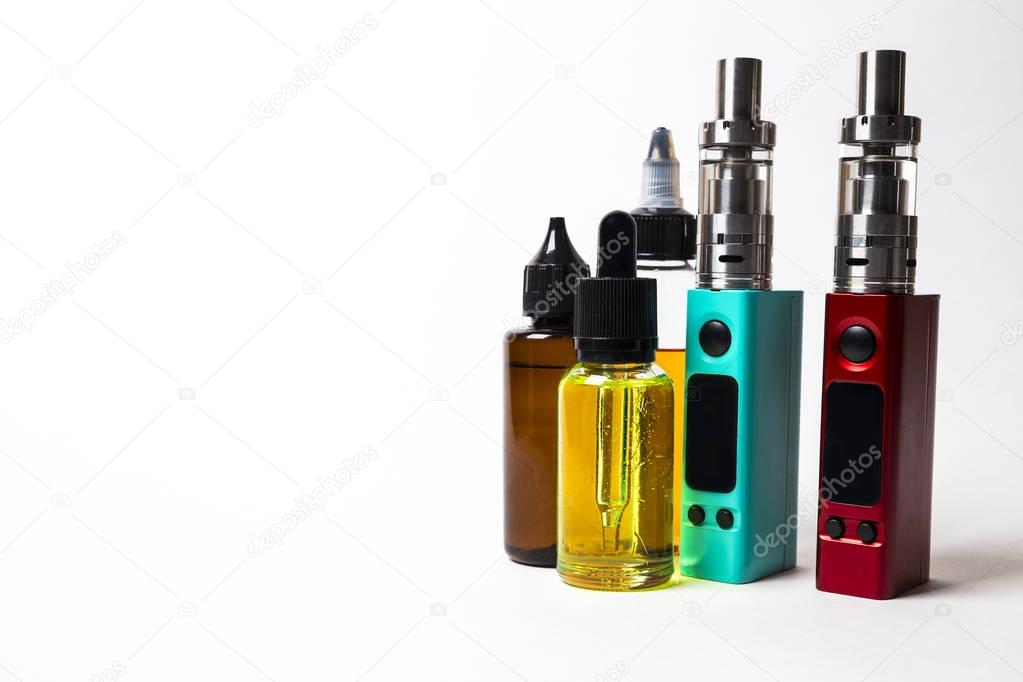 e- liquid, e-juice in the bottles and e-cigarette (vape)  isolated on the white background with copyspace