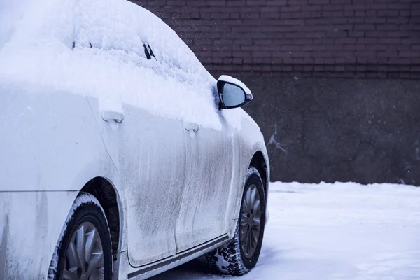冬の市の中心部に駐車場の雪で覆われている車 — ストック写真