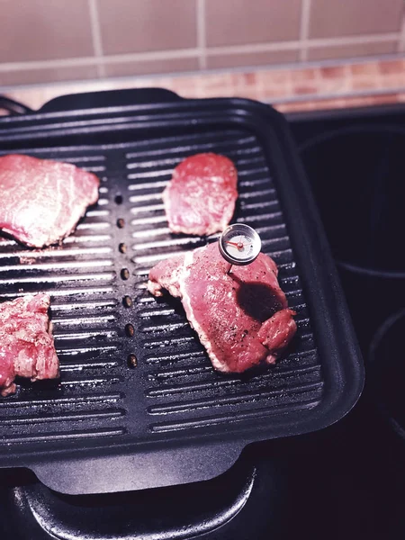 Beef steak fried on a grill with a meat thermometer to determine the degree of roasting meat (rare, medium, well) — Stock Photo, Image