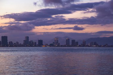 Güney Çin Denizi sahilleri ve gece Nha Trang city, Vietnam güzel günbatımı gökyüzü ile plaj üzerinden görüntülemek 