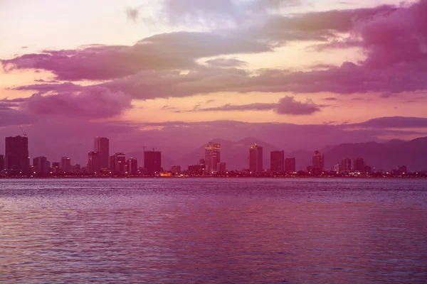 Visa från Sydkinesiska havet kusten och stranden av natten staden Nha Trang, Vietnam med vacker solnedgång sky — Stockfoto