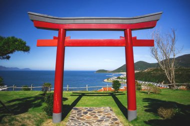 torii mavi deniz ve dağ ve arka plan üzerinde kırmızı geleneksel Japon kapısı
