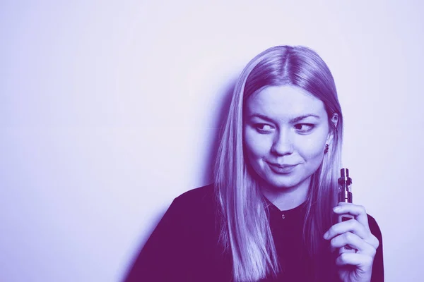 Attractive blonde girl with an expressive look holding a vape device in her hands. Trendy duotone effect — Stock Photo, Image