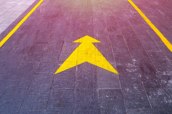 Ponteiro de seta amarelo na estrada mostra o caminho e direção — Fotografia de Stock