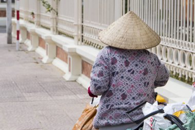 Geleneksel koni şapka ve maske Vietnam 2018-01-10 Nha Trang şehirde, sokakta bisikletle Vietnamca kadın 