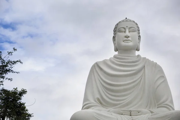 Grande statua di un Buddha bianco in posizione di loto vicino a una pagoda buddista — Foto Stock