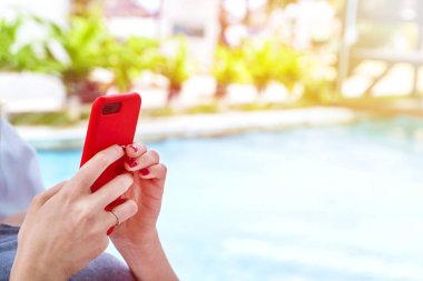 Yüzme Havuzu ile modern hareket eden telefon (smartphone) elleriyle (kopya alanı içinde yakınındaki bir tembel kız) 