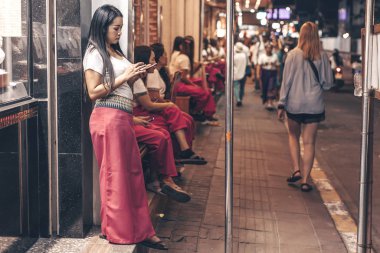 Taylandlı kadın caddede duruyor. Tayland Gece Hayatı, Pattaya 2019-12-23.
