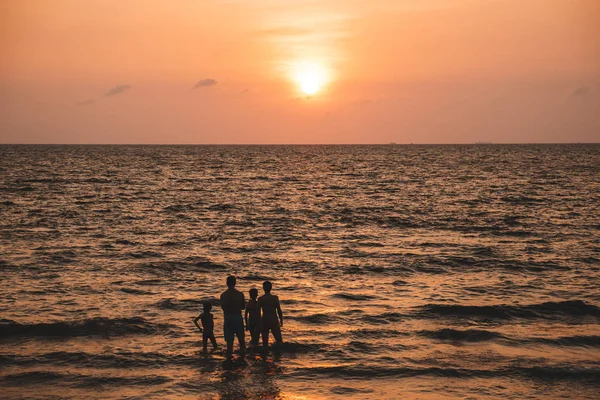 Family standing at sea and watching the sunset. Back view. Silhouette. Thailand, Pattaya 2019-12-24 — Stock Photo, Image