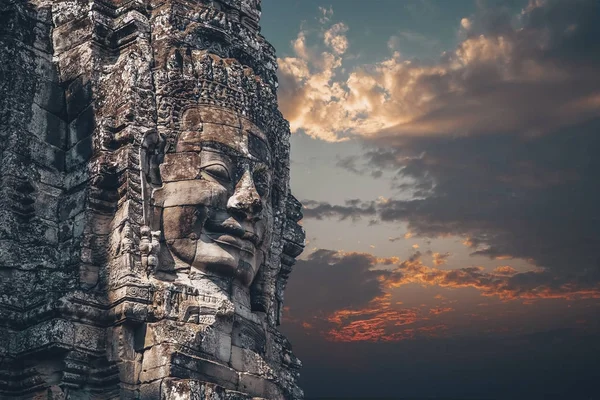 Il tempio Bayon Khmer ad Angkor Wat in Cambogia. Attrazione turistica popolare. Una pietra sorridente si affaccia sulle torri del tempio. Cielo drammatico . — Foto Stock