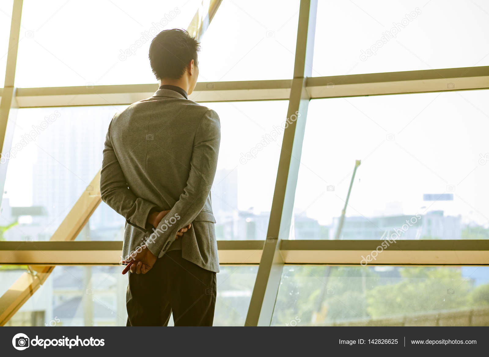 Geschäftsmann schaut aus dem Fenster Stockfotografie