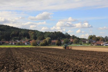 Sıcak sonbahar. Sahada çalışan traktör.