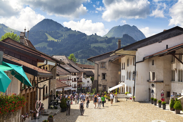 GRUYERES, CH, CIRCA JULY, 2016: View of the main street in the swiss town Gruyeres (Switzerland) on a beautiful summer day. Gruyere gives its name to the well-known Gruyere cheese