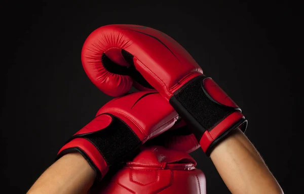 Red boxing head guard and  a pair of red boxing gloves on black bckground — Stock Photo, Image