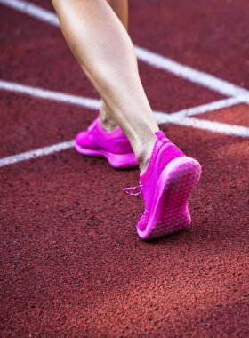 Koşu parkuru pembe ayakkabılarla güzel kadın ayak üzerinde kapat