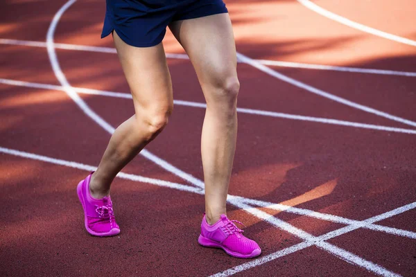 Koşu parkuru pembe ayakkabılarla güzel kadın ayak üzerinde kapat