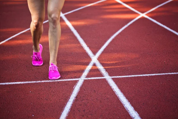 Koşu parkuru pembe ayakkabılarla güzel kadın ayak üzerinde kapat