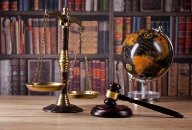 Yargıç'ın Tokmak, adalet ve hukuk kitapları arka planda ölçeklendirir. Hukuk Dairesi