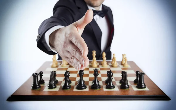 A smart man in a dark suit over the empty chessboard challenging you!