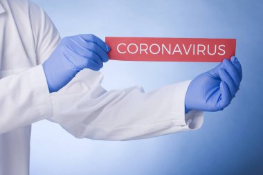 Coronavirus Karantinası, yazılı uyarı işareti beyaz önlüklü, eldivenli, yüzü tıbbi maskeli doktorların elinde. Karantina koronavirüsü salgını. Coronavirüs salgını.