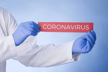 Coronavirus Karantinası, yazılı uyarı işareti beyaz önlüklü, eldivenli, yüzü tıbbi maskeli doktorların elinde. Karantina koronavirüsü salgını. Coronavirüs salgını.