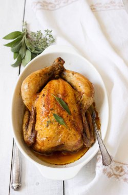 Beyaz bir arka plan üzerinde otlar ile pişmiş tavuk.