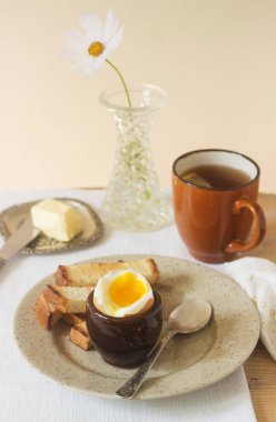 Kahvaltı, haşlanmış yumurta, kruton, tereyağı ve çay