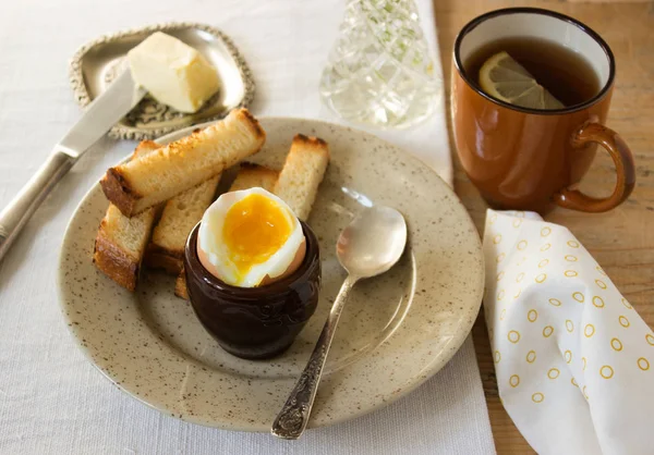 Сніданок, варене яйце, грінки, масло і чай — стокове фото