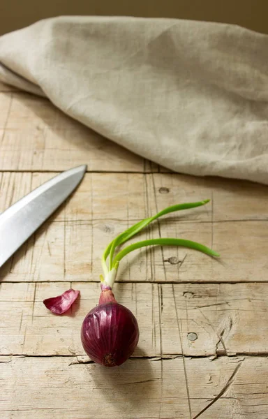 Red onion and knife on a wooden table — Stock Photo, Image
