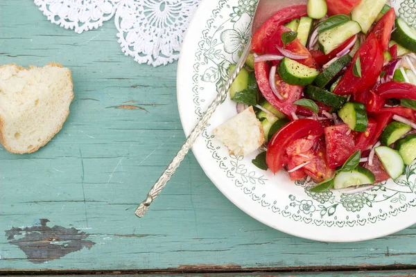 A refreshing classic summer salad often found at cookouts and picnics is made with tomatoes, cucumber, onion and basil. Selective focus was used on this image. — Stock Photo, Image