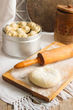 Traditional pelmeni or dumpling at cutting board. Homemade preparation food. clipart