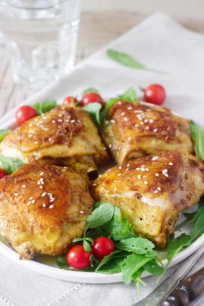 Garnitür roka ve domates ile pişmiş tavuk uyluk. Rustik tarzı, seçici odak.