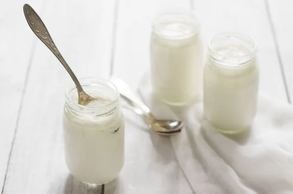 Yogurt buatan sendiri dalam botol kaca di atas meja kayu. Gaya Rustik, fokus selektif . — Stok Foto
