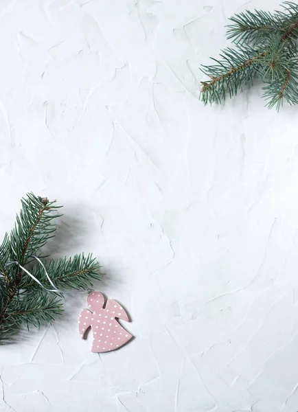 Nieuwjaar of Kerstmis achtergrond: angel en Spar takken op wit beton achtergrond. Postkaart. Bovenaanzicht, kopie ruimte. — Stockfoto