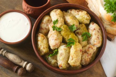 Lahana ekşi krema, ekmek ve şarap ile hizmet alır. Dolma, sarma, sarmale, golubtsy veya golabki.