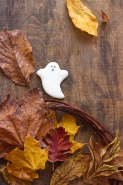 Cadılar Bayramı, hayalet gingerbread dekore edilmiş ahşap arka plan üzerinde sonbahar yaprakları ile.