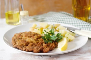 Patates salatası ile servis şnitzel limon. Geleneksel Avusturya yemekleri.