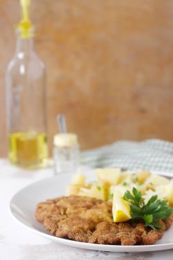 Patates salatası ile servis şnitzel limon. Geleneksel Avusturya yemekleri.