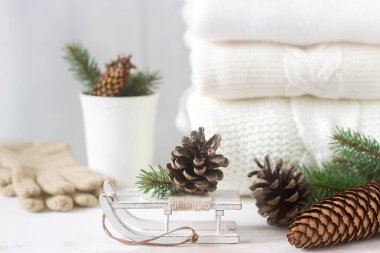 Kış konsepti ile beyaz battaniye kazak, eldiven, kızaklarımız, Kupası, koni ve çam dalları.