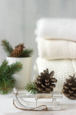Kış konsepti ile beyaz battaniye kazak, eldiven, kızaklarımız, Kupası, koni ve çam dalları.