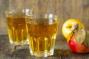 Gözlük ve ahşap arka plan üzerinde taze elma elma suyu. Rustik tarzı.